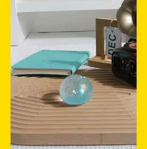 Gros plan d'une balle anti-stress bleue pailletée sur un plateau en bois naturel