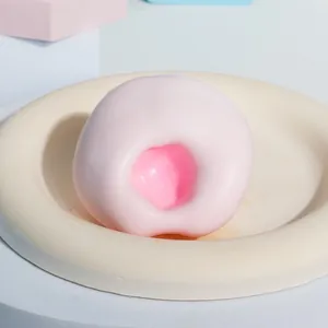 Macro-weergave van een zacht roze mochi-vormig TPR squishy speeltje op een beige bord