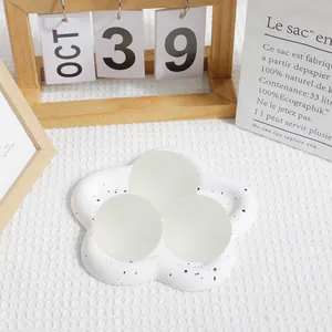 Gros plan de trois balles antistress au maltose sur un plateau décoratif en fleur.