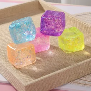 Gros plan de cubes spongieux à paillettes colorées pour soulager le stress en plateau
