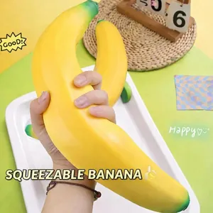 Vue macro d'un grand jouet antistress en forme de banane jaune à presser à la main.