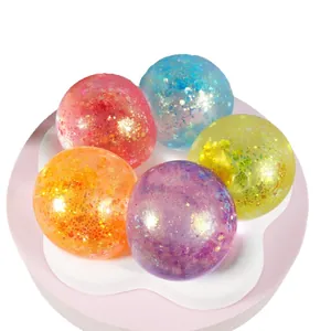 Lot de cinq balles antistress à paillettes colorées sur un support rose élégant