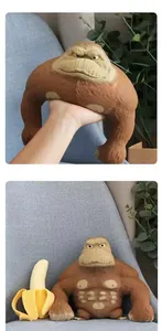Close-up of a muscular brown gorilla toy being stretched by hand and sitting on a chair