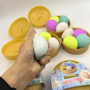 Close-up of a hand squeezing a soft rainbow bun squishy toy in a steamer basket