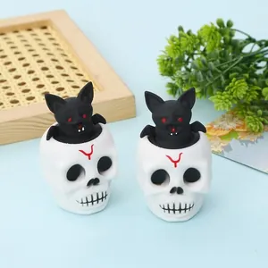 Detailed view of two Halloween skull squeeze toys featuring black bats popping out