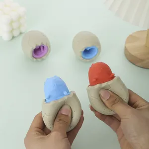 Close-up of hands squeezing a dinosaur egg squishy toy to pop the colorful dinosaur out.