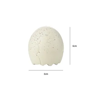 Detailed perspective of the 6cm cream speckled dinosaur egg shaped squeeze stress toy