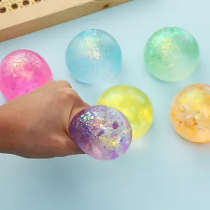 Close-up of hand squeezing a purple glitter-filled maltose anti-stress ball