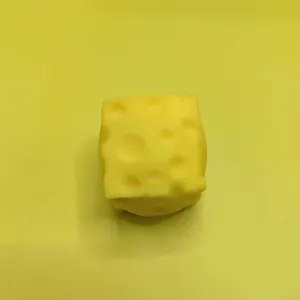 Macro view of a soft yellow square cheese squishy toy designed for creative stress relief