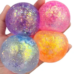 Close-up of four colorful glitter-filled squishy balls held in a hand for stress relief.