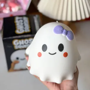 Primer plano de un juguete blandito fantasma de Halloween blanco con lazo morado