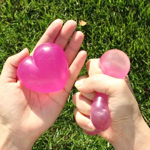Jouet antistress translucide en forme de cœur rose en maltose sur l'herbe verte