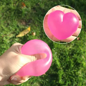 Jouet de compression en forme de cœur rose pour le stress tenu dans la main