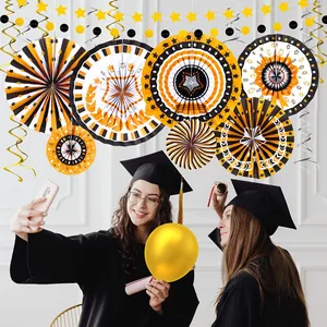 Primer plano de decoraciones de graduación con abanicos de papel en una escena de fiesta.