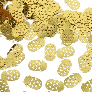 Macro view of golden pineapple-shaped party confetti featuring heart-shaped cutouts