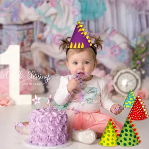 Adorabile bambino con cappello da dinosauro per la festa del suo primo compleanno.