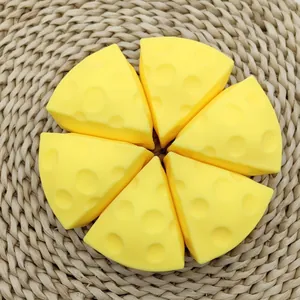 Close-up of six yellow cheese-shaped stress relief squishy toys on a woven mat
