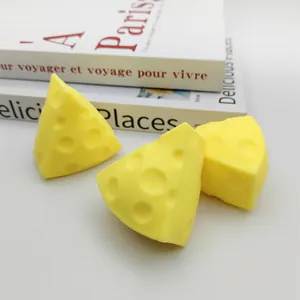 Close-up of three yellow cheese-shaped stress relief squishy toys with porous texture