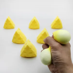 Detail of hand squeezing a cheese-shaped yellow stress relief vent toy.