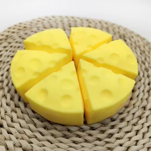 Close-up of yellow triangular cheese slice squishy toys on a natural woven mat background.