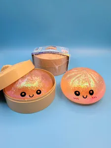 Détail d'un jouet bun squishy orange pailleté avec un visage souriant et un panier vapeur