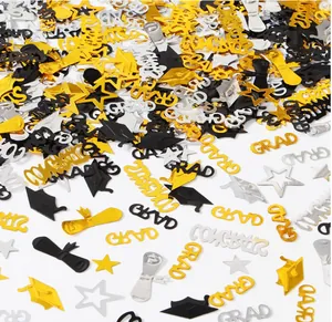 Dettaglio di coriandoli per festa di laurea in oro e argento con scritte di auguri