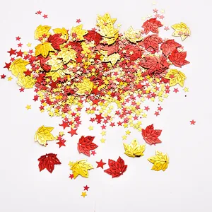 Close-up of red and gold maple leaf and star sequins for Thanksgiving party decor