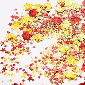 Detail macro view of festive red and gold maple leaf and star shaped PVC confetti