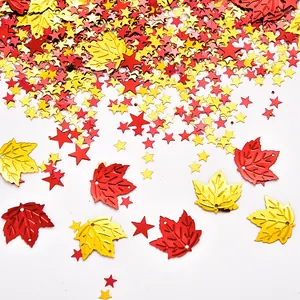 Close-up of red and gold maple leaf and star-shaped PVC confetti for Thanksgiving.