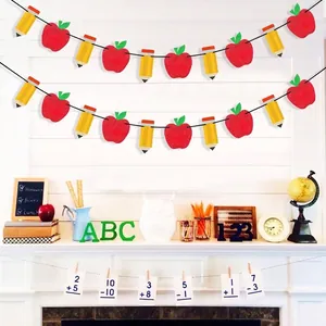 Apple and pencil garland hanging on a fireplace mantel for school classroom decoration
