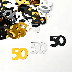 Close-up of gold, silver, and black 50th birthday party table confetti decorations.