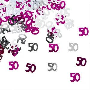 Detail shot of scattered 50th birthday number confetti in magenta and silver foils