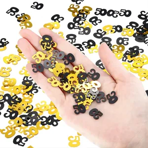 Close-up of gold and black number 50 confetti pieces held in a hand for scale