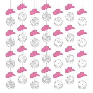 Chapeau de cowboy rose et boule disco décorations de fête pour thème cowboy occidental.