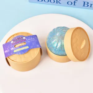 Jouet anti-stress dumpling bleu pailleté dans son emballage de mini panier vapeur de bambou