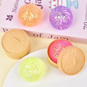 Gros plan de jouets squishy baozi colorés et pailletés avec mini paniers vapeur