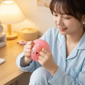 Vue détaillée d'un jouet squishy rose pailleté en forme de brioche pressé pour décompresser.