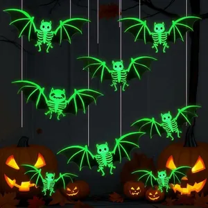 Close-up of glow-in-the-dark green bat skeleton hanging decorations for Halloween.