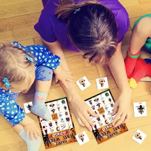 Nahaufnahme einer Familie, die Halloween-Bingo-Partykarten auf Holzboden spielt.