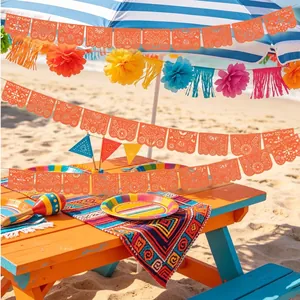Πορτοκαλί μεξικάνικο πανό Papel Picado σε ένα ζωντανό σκηνικό πάρτι στην παραλία