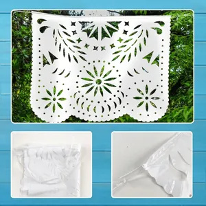 Λεπτομερής προβολή λευκού πλαστικού πανό papel picado με όμορφα φλοράλ σχέδια.