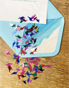 Colorful dinosaur shaped metallic confetti scattered for Jurassic theme party table decorations