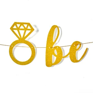Detail shot of gold glitter wedding banner with diamond ring icon and be lettering