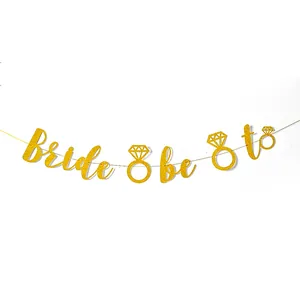 Glittery gold Bride to be party banner featuring elegant diamond ring cutouts for wedding decor