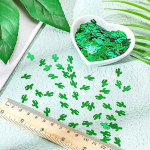 Green cactus shaped PVC party confetti sprinkles shown with ruler for scale reference
