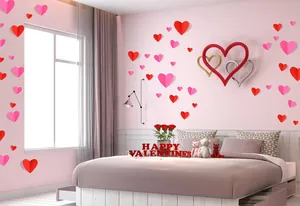 Adesivi murali cuore 3D romantici che decorano una camera da letto rosa per San Valentino.