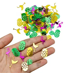 Close-up of tropical Hawaii party confetti with pineapple and flamingo shapes held in hand