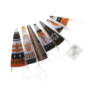 Detalle de 6 abanicos de papel plegados naranja y negro con clips para decoración
