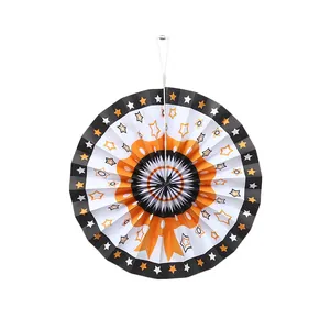 Detalle de un abanico de papel decorativo naranja y negro con estrellas para decoración.