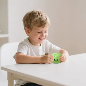 Bambino che gioca con un giocattolo squishy baozi verde sorridente per il relax